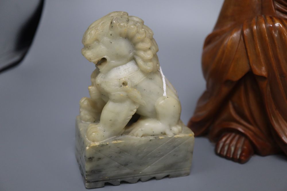 A Japanese rootwood carving of a seated elder, inset eyes and teeth and a pair of Chinese soapstone shishi, each crouched on a rectangu